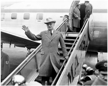 Photograph of President Truman waving from the steps as he prepares to board his airplane in Washington for a... - NARA - 200343