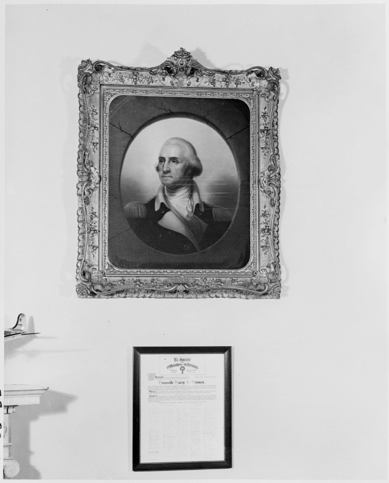 Photograph of the portrait of George Washington and an honorary certificate hanging on the wall of the Oval Office in... - NARA - 199469