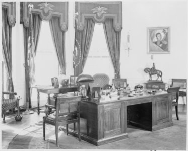 Photograph of the President's desk and other furnishings in the Oval Office of the White House. - NARA - 199476