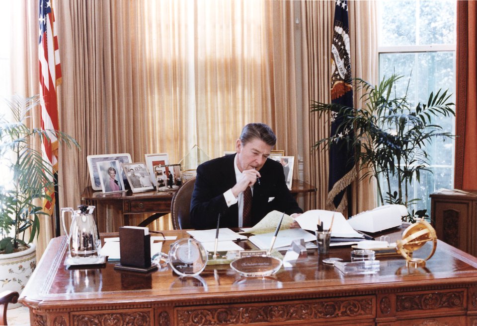 Photograph of President Reagan working at his Oval Office desk - NARA - 198526