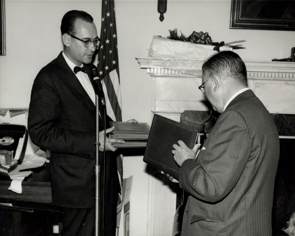 Photograph of Dr. James B. Rhoads Presenting Book of Tributes to Dr. Grover at His Retirement Party, 1965