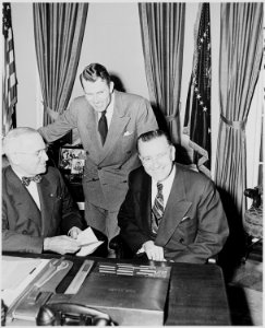 Photograph of President Truman at his desk in the Oval Office with Secretary of the Interior Oscar Chapman and... - NARA - 200262