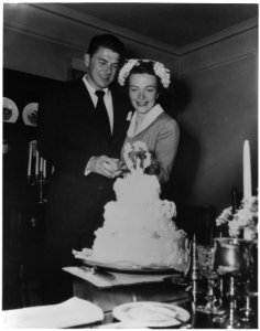 Photograph of Newlyweds Ronald Reagan and Nancy Reagan cutting their wedding cake - NARA - 198602 photo