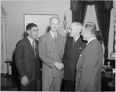 Photograph of President Truman greeting crew members from an around-the-world flight in the Oval Office. - NARA - 199590