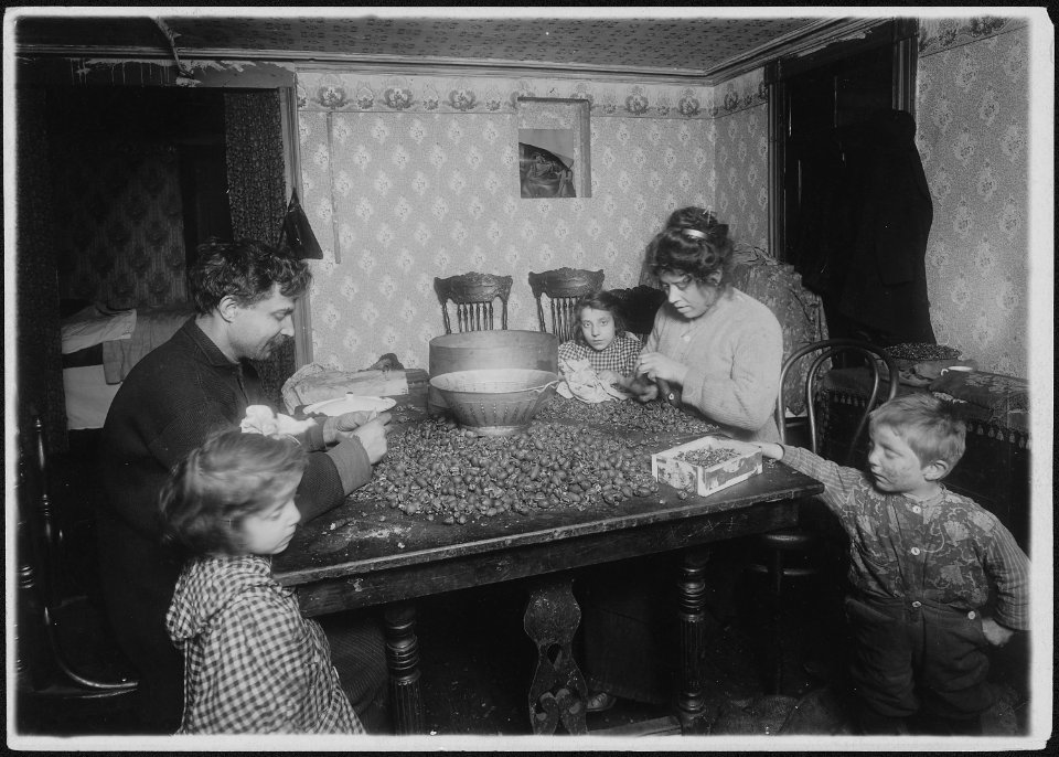 Picking nuts in dirty basement. The dirtiest imaginable children were pawing over the nuts eating lunch on the tabel... - NARA - 523499