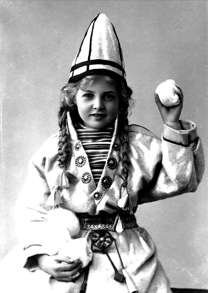 Pike i sameliknende drakt med kofte, lue og belte. I hendene holder hun jukse snøballer - Norsk folkemuseum - NF.25780-858