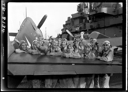 Pilots leaning across F6F on board the USS Lexington (CV-16) after shooting down 17 out of 20 Japanese planes heading... - NARA - 520896