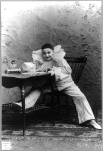 Pilar Morin as clown-mime- full lgth., seated at table LCCN2003662115