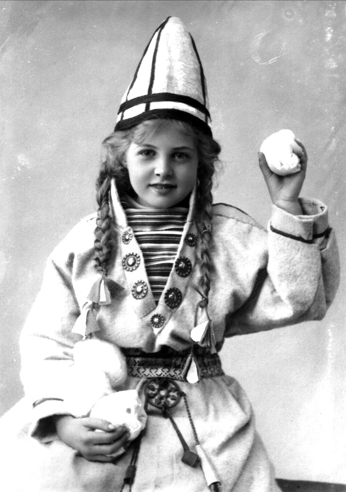 Pike i sameliknende drakt med kofte, lue og belte. I hendene holder hun jukse snøballer - Norsk folkemuseum - NF.25780-857