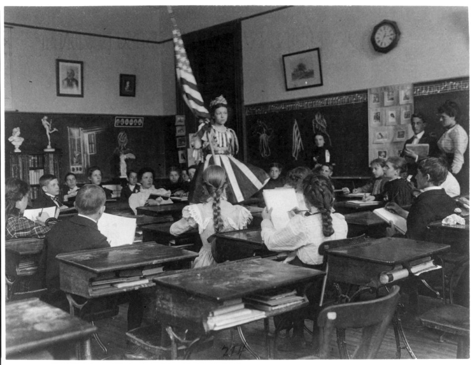 Public school students in art class sketching live model wearing stars-and-stripes dress and holding U.S. flag, 3rd Division Washington, D.C. LCCN2001703708