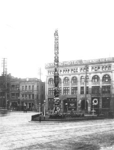 Pioneer Square totem pole with the Olympic Block in the background, Seattle, ca 1911 (WARNER 629) photo