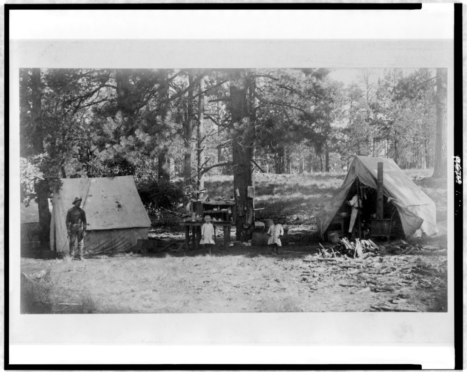 Pvt. Holmes and Pvt. Desmukes, of the 10th Cavalry, with two children, Lillian Mearns and Luther Williams, in kitchen camp at Fern Spring, near Baker's Butte, Mogallon Mountains, Arizona LCCN96514529