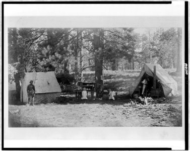 Pvt. Holmes and Pvt. Desmukes, of the 10th Cavalry, with two children, Lillian Mearns and Luther Williams, in kitchen camp at Fern Spring, near Baker's Butte, Mogallon Mountains, Arizona LCCN96514529
