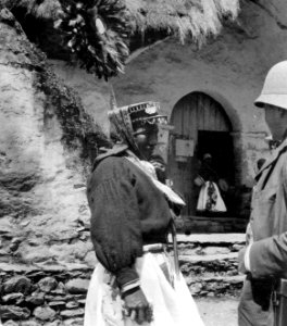 Quichaindian med solformig fjäderprydnad på huvudet. Utanför kyrkan under påskfesten. Pelechuco - SMVK - 002506