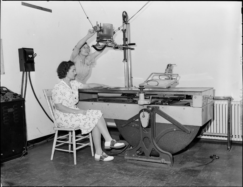 R.N., Hazel Jamison, adjusts the X-Ray machine in company dispensary for X-Ray photograph of patient's arm. Koppers... - NARA - 540951