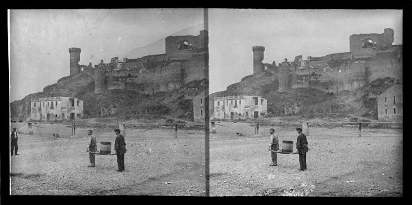 Platja amb dos homes i vista de la vila vella i la muralla de Tossa