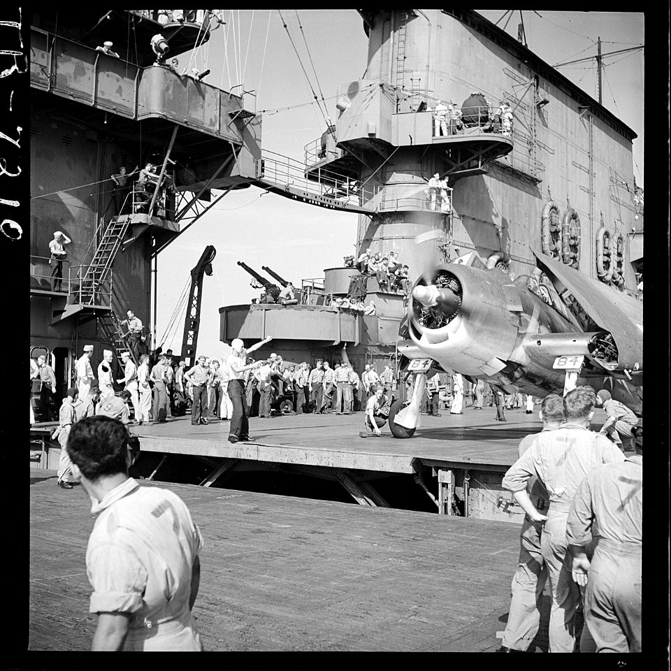 Plane on board the USS Saratoga (CV-3). Plane parker signaling to pilot of F6F. - NARA - 520893