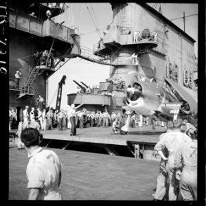 Plane on board the USS Saratoga (CV-3). Plane parker signaling to pilot of F6F. - NARA - 520893