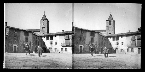 Plaça de Taradell amb gent , un home dalt d'un ruc i , al fons , el campanar