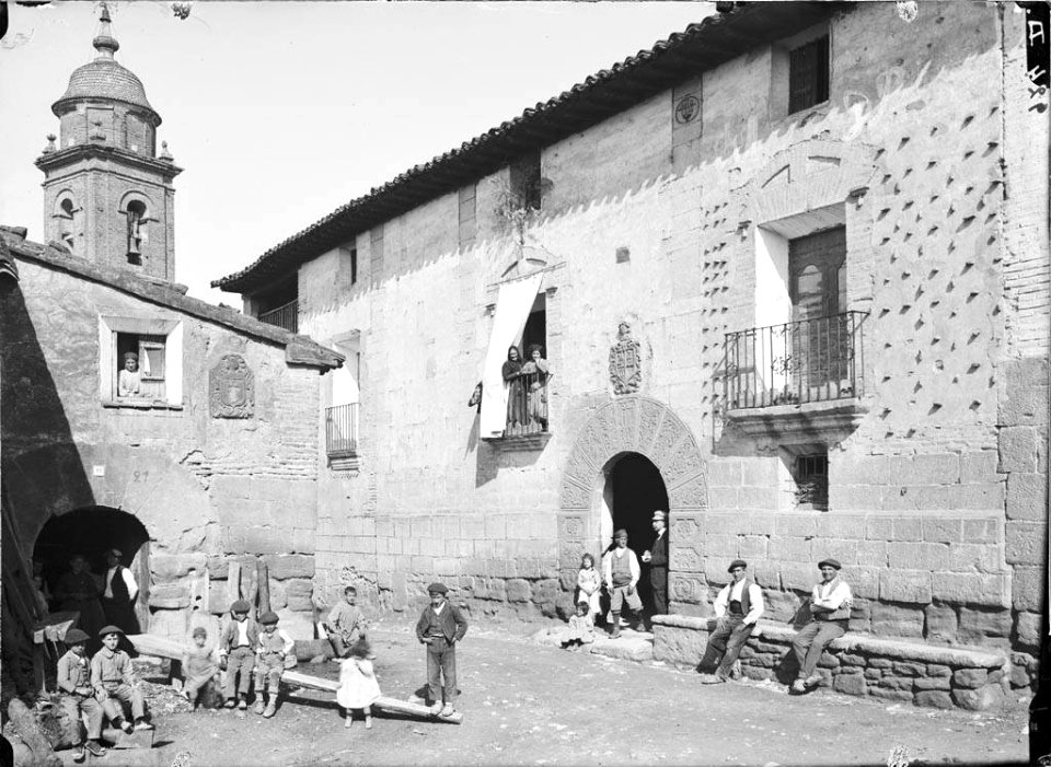 Plaça amb una casa senyorial i gent al poble de Liesa