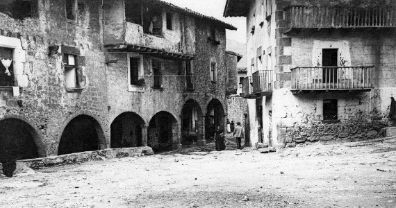 Plaça porxada de Santa Pau amb gent