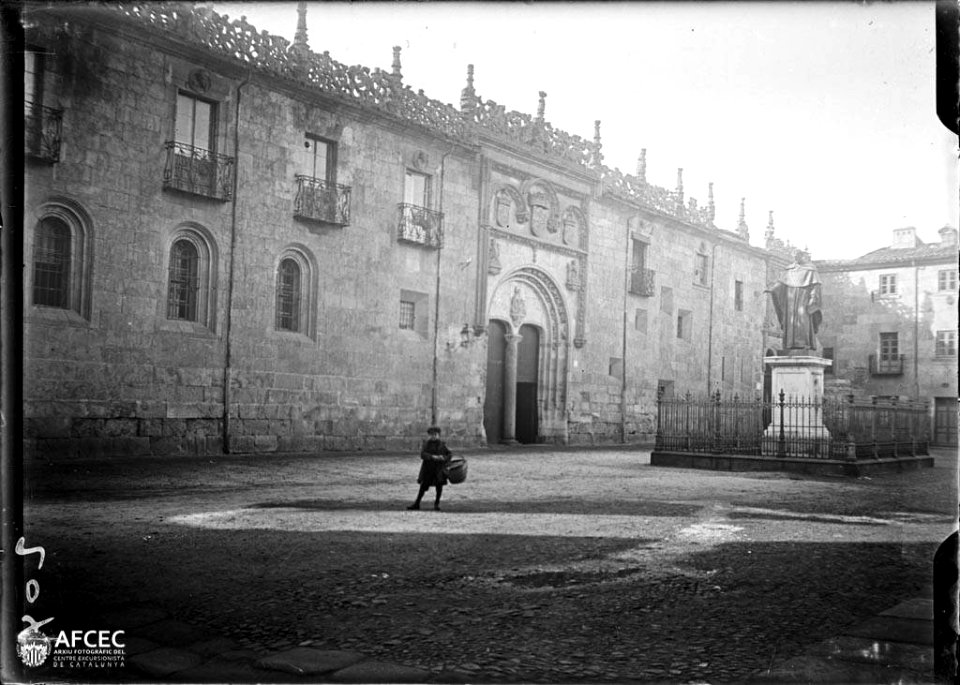 Plaça davant els edificis de la Universitat de Salamanca amb un monument i un nen