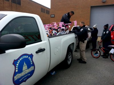 Police officers load bicycles donated to the Toys for Tots program 131217-N-CG900-005