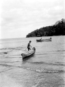 Pojke i kanot samt expeditionens motorbåt. Pearl Islands. Panama - SMVK - 004140