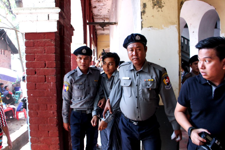 Police escort detained Reuters journalist Kyaw Soe Oo