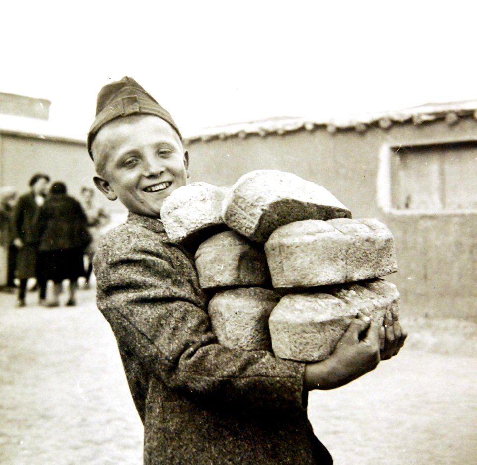 Polish youngster carrying bread made from Red Cross flour at an evacuation camp, Iran, 1943 (35535341954)