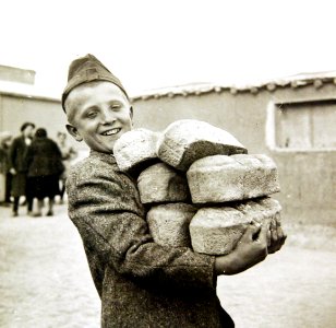 Polish youngster carrying bread made from Red Cross flour at an evacuation camp, Iran, 1943 (35535341954)