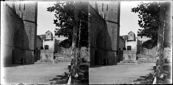 Portal del monestir de Pedralbes amb gent i una nena rere un arbre en primer terme