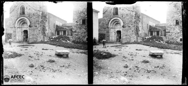 Portal i façana de l'església de Sant Pere d'Albanyà amb algunes persones al carrer