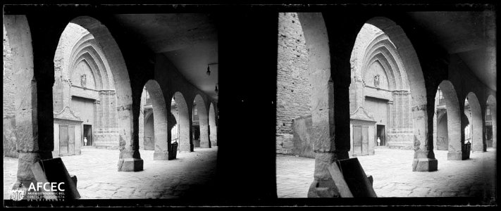Porta lateral de l'església de Cardona vista des dels porxos d'un carrer