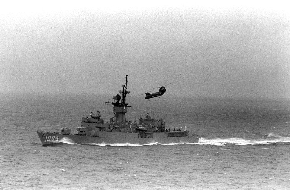Port bow view of USS Pharris (FF-1094) underway in the Mediterranean with CH-46 moving away after vertical replenishment 1986 DN-SN-86-10295