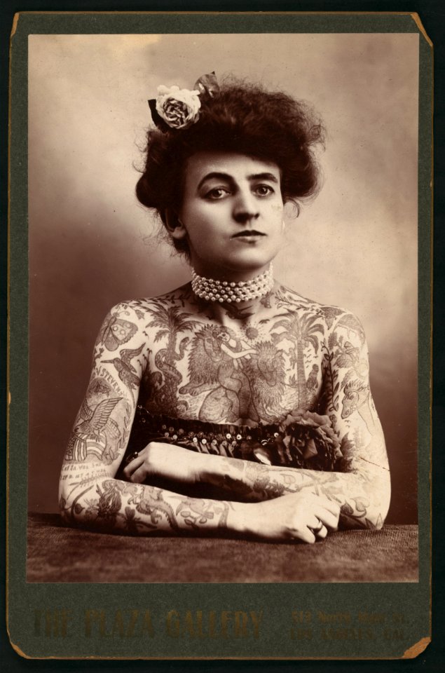 Portrait of a woman showing images tattooed or painted on her upper body LCCN2006687059