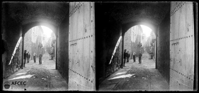 Portal del carrer del castell de Solsona amb un grup d'homes en primer terme i una dona al fons (AFCEC TORRAS B 11264)