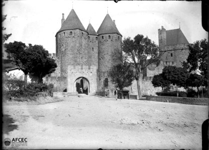 Portal, torres i muralla de la ciutat de Carcassona i un carro amb un home