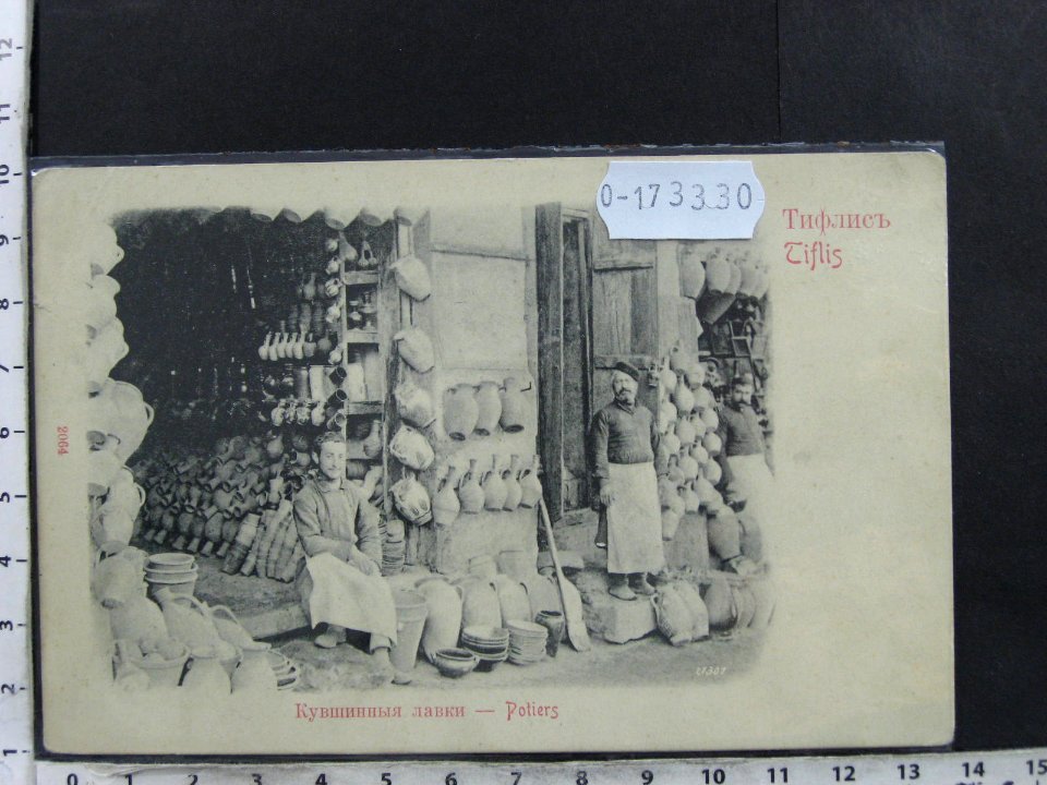 Postcard of men with pottery in front of two stores, Tbilisi, Georgia. Photo by Ermakov