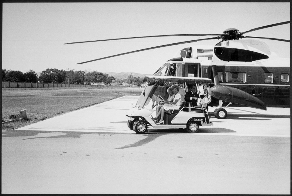 President and Mrs. Nixon and Tricia Nixon, on golf cart, approaching Marine One - NARA - 194682