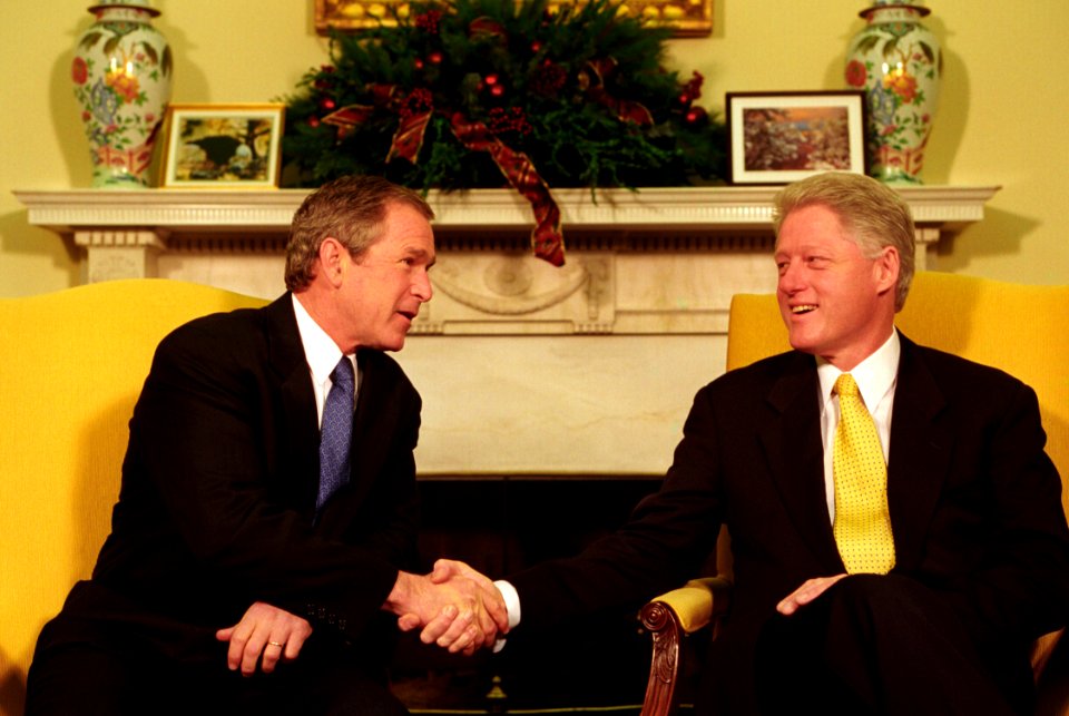 President Bill Clinton and President-Elect George W. Bush shake hands during their meeting in the Oval Office