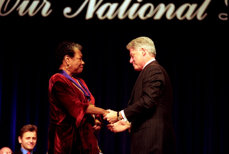 President Bill Clinton and Maya Angelou clasp hands following her being presented with the National Medal of Arts and Humanities