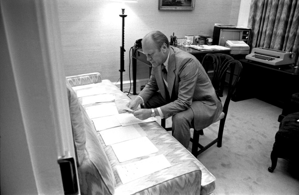 President Gerald Ford examines documents related to potential Vice Presidential nominees