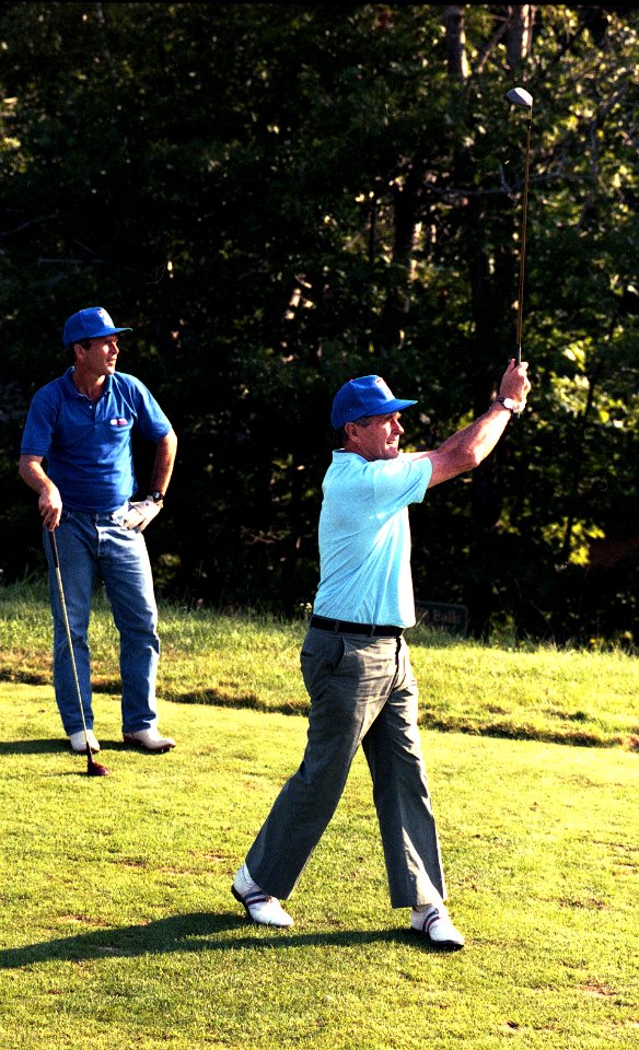 President George H. W. Bush golfing with George W. Bush