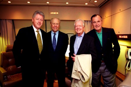 President Bill Clinton and former Presidents Gerald Ford, Jimmy Carter, and George H. W. Bush abord Air Force One