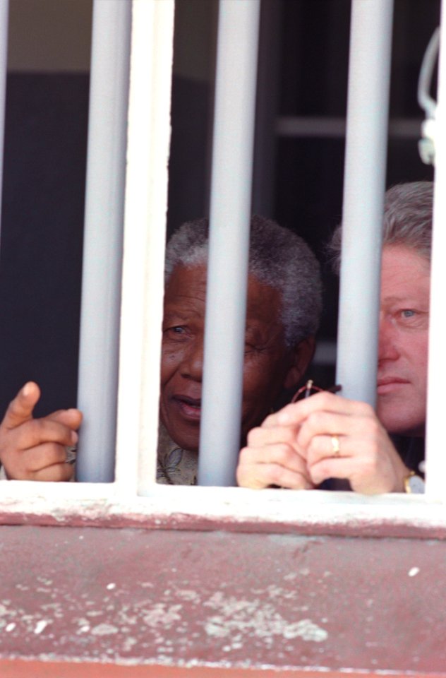President Bill Clinton and President Nelson Mandela view Cell Block B where President Mandela was imprisoned