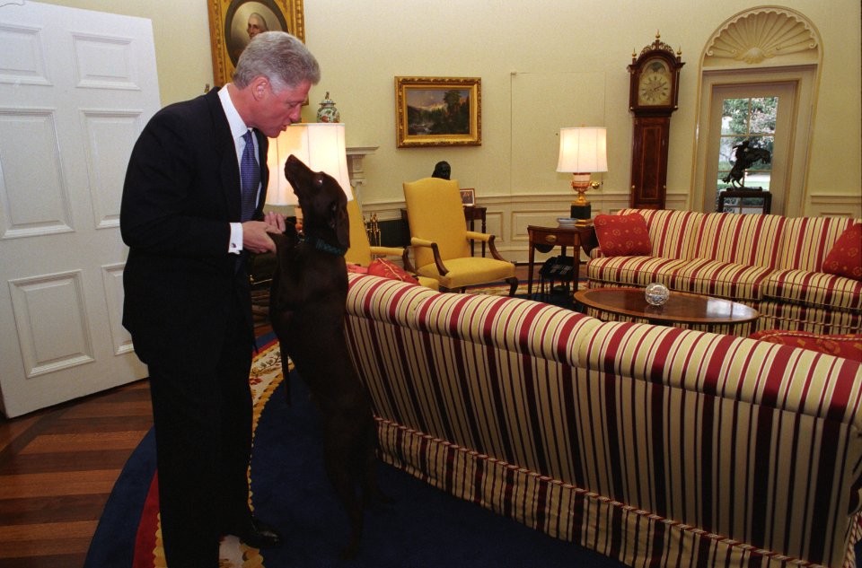 President Bill Clinton holds Buddy's front paws and Buddy jumps up to greet him