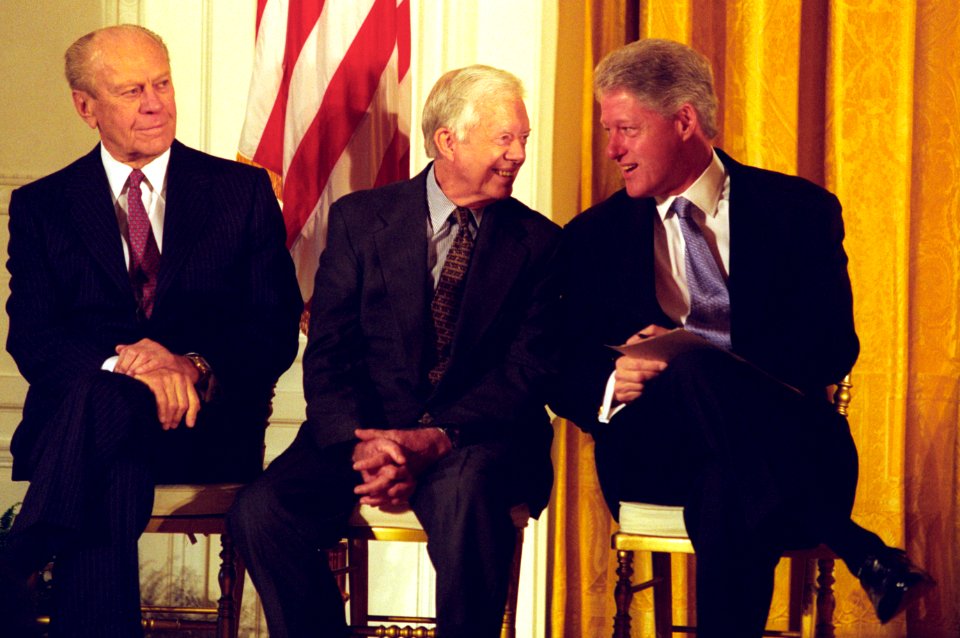 President Bill Clinton talks with former President Jimmy Carter as former President Gerald Ford looks on, at a China trade event