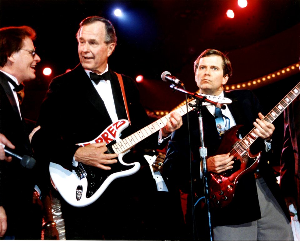 President George H. W. Bush and Lee Atwater play the guitar at the celebration for young Americans at the DC Armory