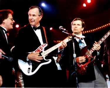 President George H. W. Bush and Lee Atwater play the guitar at the celebration for young Americans at the DC Armory